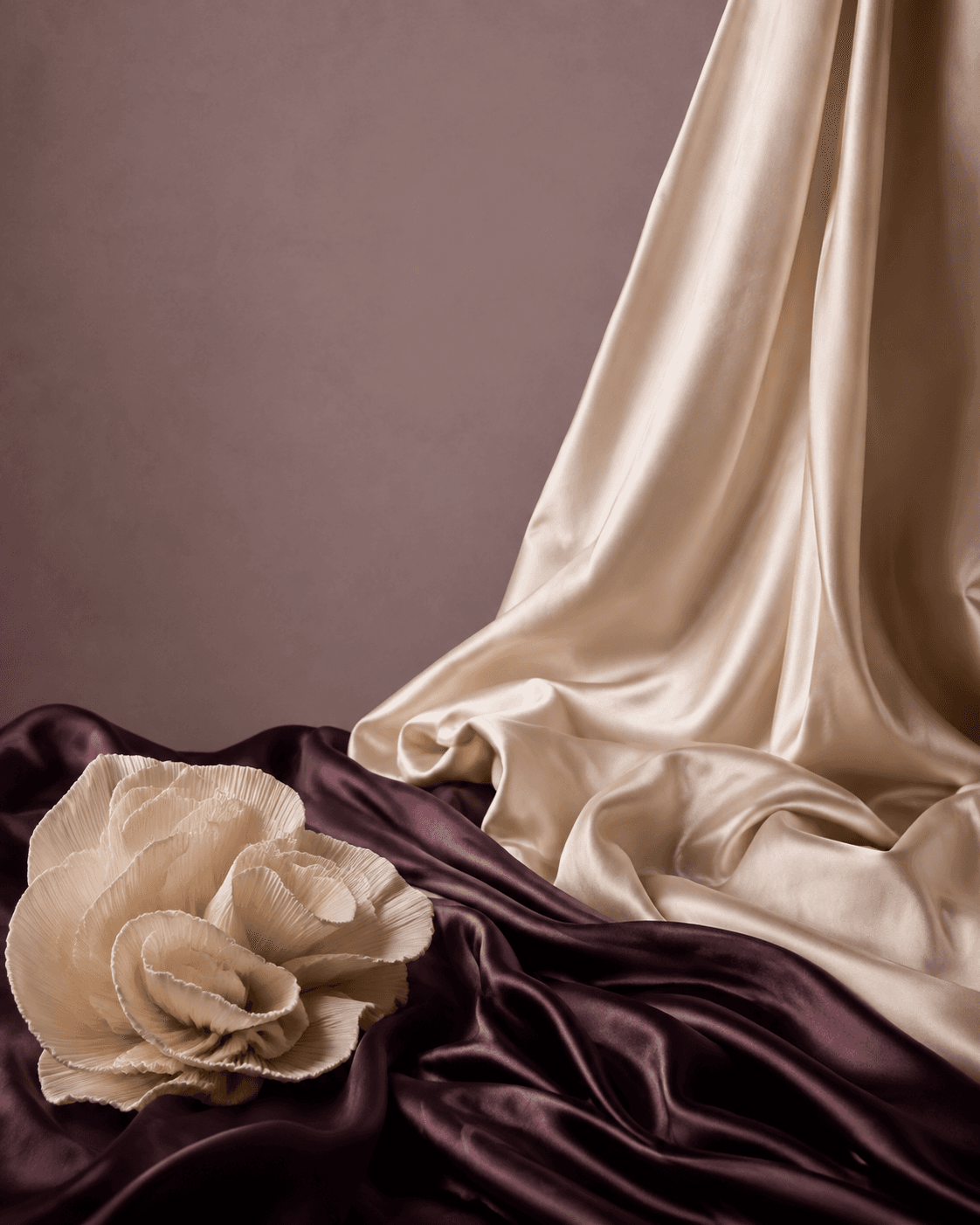 Ivory and aubergine silk arranged in soft sculptural folds